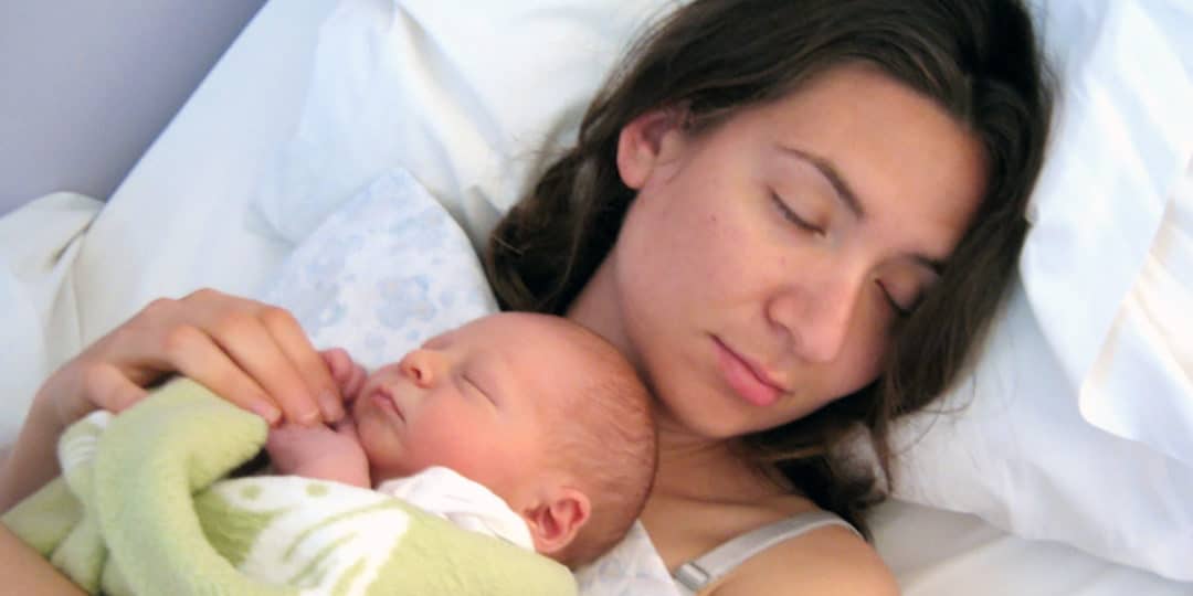 Mother sleeping with infant