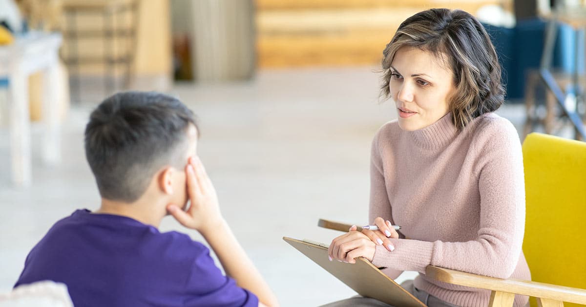 Woman with clipboard consulting boy